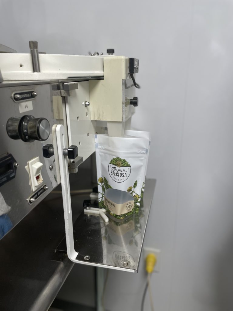 Machine filling kratom tablet bags according to GMP procedure. Showing how kratom is made.