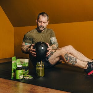 Man using exercise ball with Super Speciosa's kratom products and kratom drink.