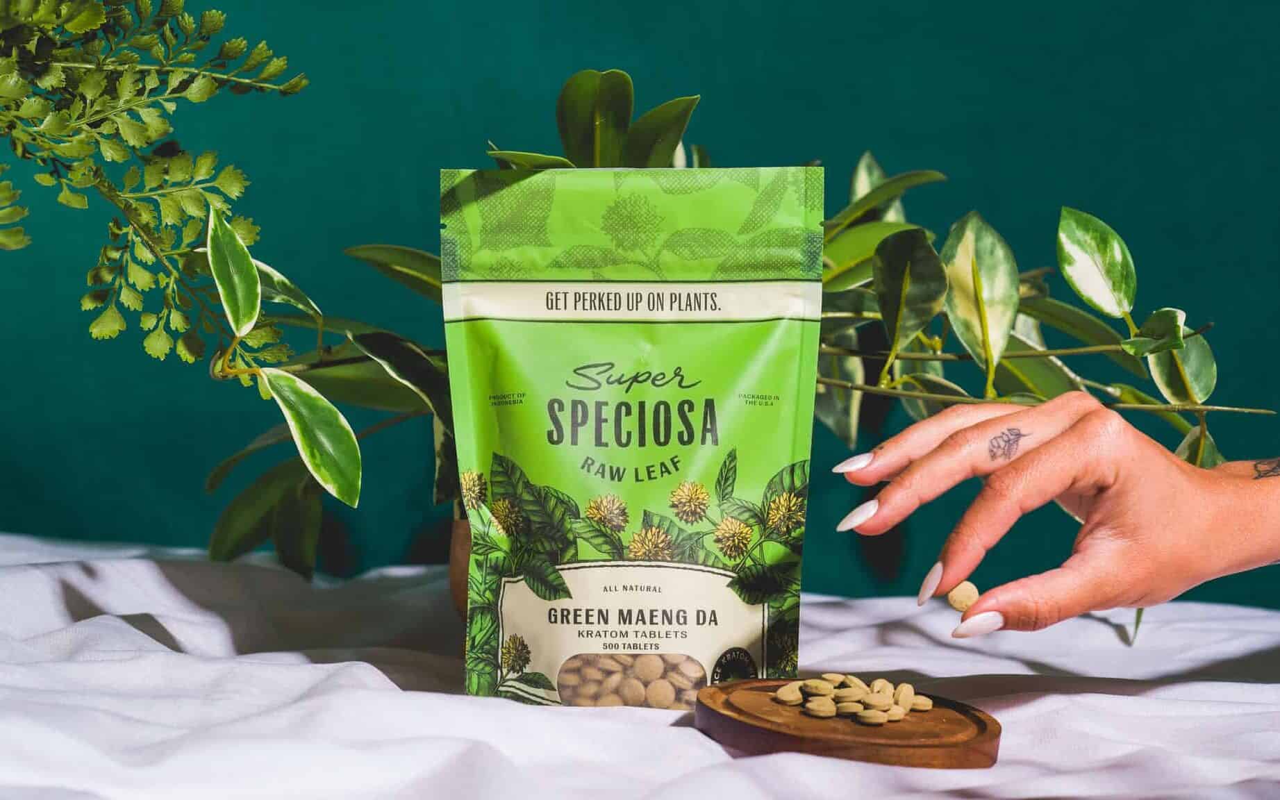 Choosing the right kratom tablets for you: Super Speciosa's Green Maeng Da kratom tablets, stylized with greenery and woman's hand picking up kratom tablet. Buy kratom tablets from Super Speciosa!